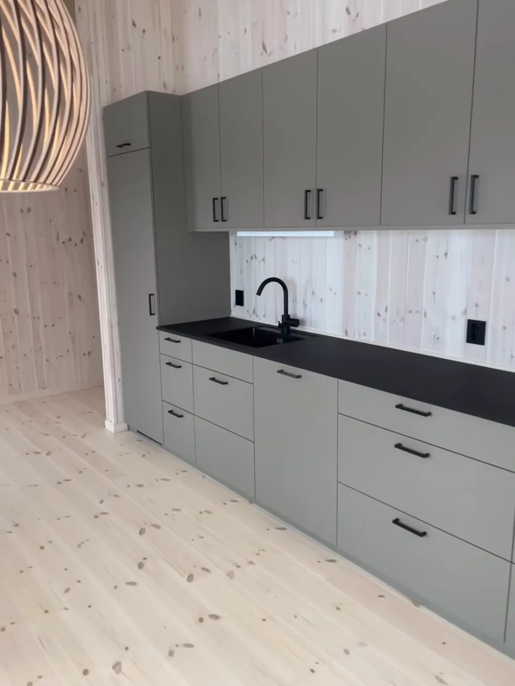 Grått kjøkken og lyst panel