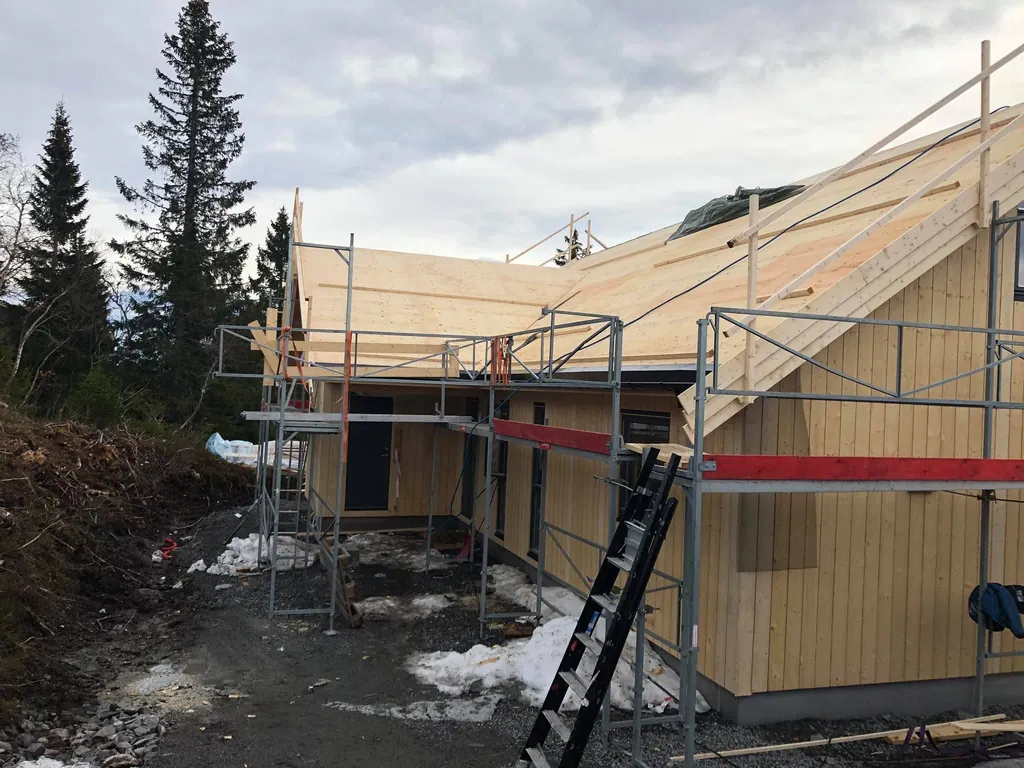 Hytte i kveldssol, stillas og takbord